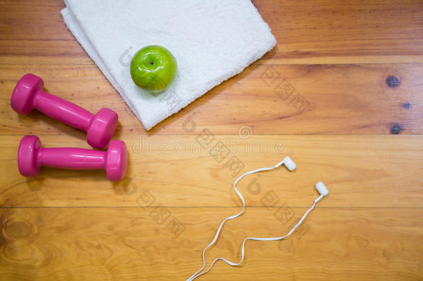 健身房设备和苹果放在木地板上