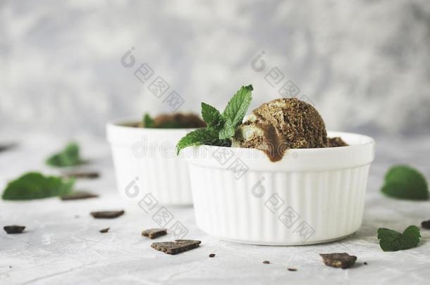 白碗巧克力薄荷冰淇淋，大理石桌上放着巧克力和薄荷叶