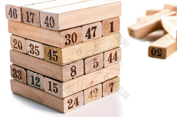 白色背景上的游戏块Jenga。 垂直塔整体和游戏。 积木堆叠，数字数字