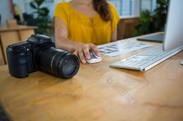 数码相机保持桌子和平面设计师在后台工作