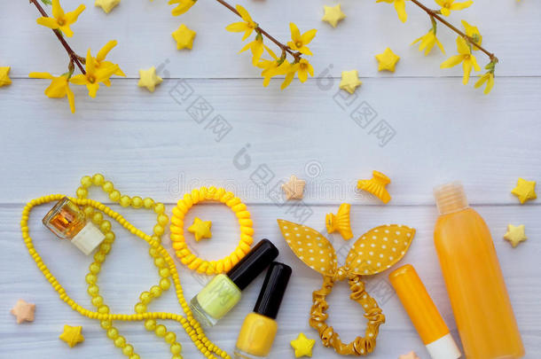 年轻女孩或青少年黄色配饰的组成。 指甲油，口红，发夹，带子，珠子，手镯，香水
