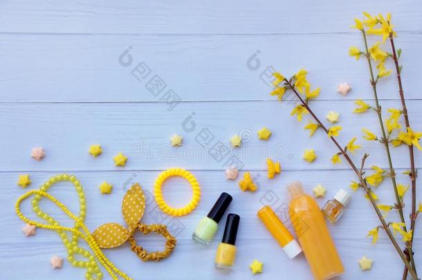 年轻女孩或青少年黄色配饰的组成。 指甲油，口红，发夹，带子，珠子，手镯，香水