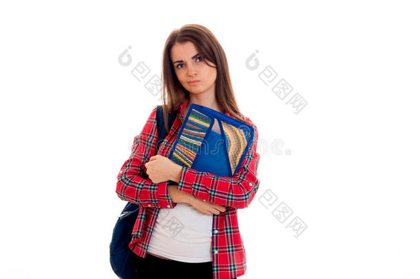 沉思的十几岁的女孩穿着格子衬衫看向一边，拿着一个文件夹