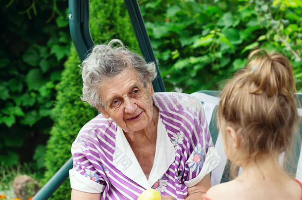 祖母和孙女-年长的女人在户外谈论她的孙女
