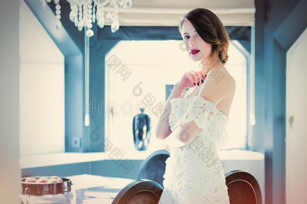 美丽的年轻女人站在轻奢室的桌子附近
