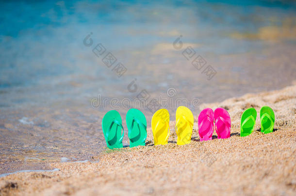 一家人五颜六色的拖鞋在海边的海滩上