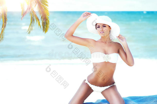 美丽美丽的年轻女孩在夏天的海滩上放松