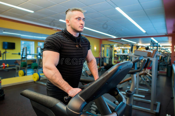 有吸引力的年轻肌肉男，同时在健身房的<strong>跑步</strong>机上<strong>跑步</strong>