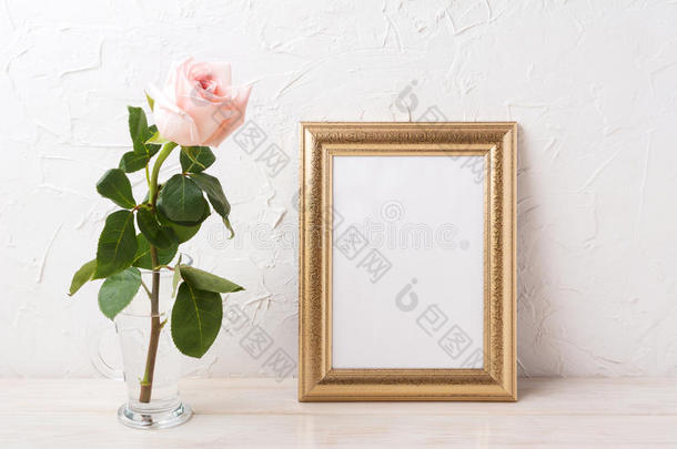 金色框架模型与温柔的淡粉色玫瑰在玻璃