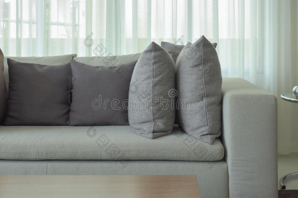 灰色枕头在米色沙发与纯粹的背景
