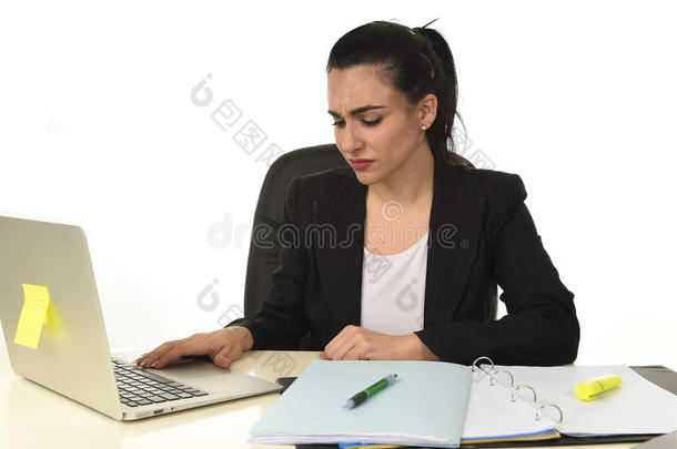 穿着西装的有魅力的女人在办公室的电脑桌上工作很累很无聊，看上去很难过
