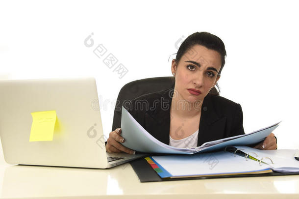 穿着西装的有魅力的女人在办公室的电脑桌上工作很累很无聊，看上去很<strong>难过</strong>
