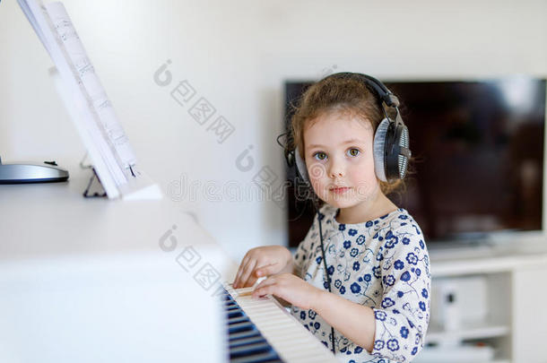 漂亮的小女孩在客厅或音乐<strong>学校</strong>弹<strong>钢琴</strong>