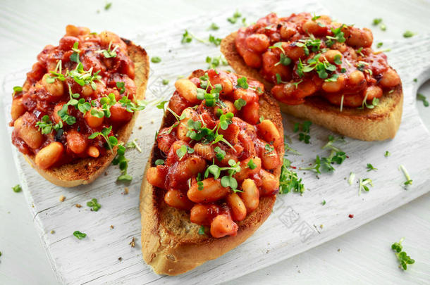 豆子用番茄酱在烤面包上用十字色拉洒