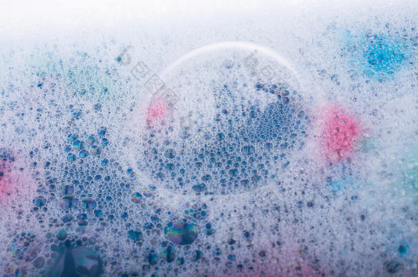 蓝色的水覆盖着泡沫和洗发水的气泡