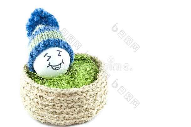 篮子里的复活节鸡蛋。 带有POM的针织帽子中的表情符号。 黄麻针织篮子，剑麻绿色。 手工制作。