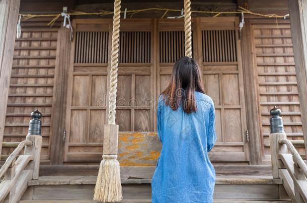 背面的女人在日本寺庙里敲钟