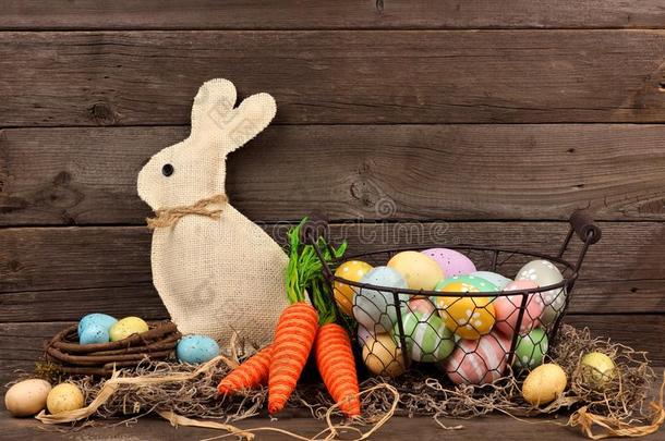 复活节场景与兔子，胡萝卜和篮子鸡蛋在木头上