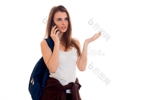 一个年轻的女孩穿着一件t恤，肩上背着一个背包，一个严肃的人在打电话