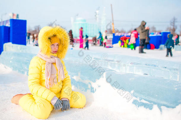 可爱的小女孩在温暖的冬天在户外溜冰场滑冰