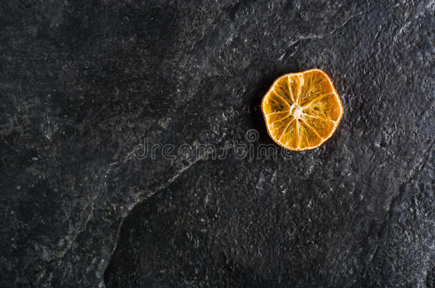 黑色石板背景上的柑橘类<strong>水果干</strong>片。