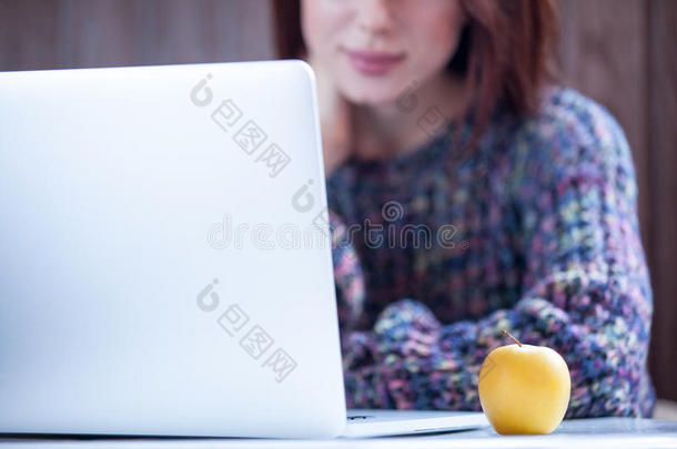 漂亮的年轻女人在苹果附近的键盘上打字