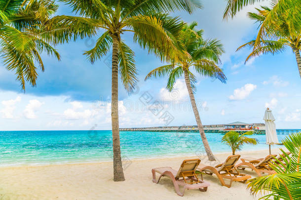 海滩椅子与伞在马尔代夫岛，白色沙滩