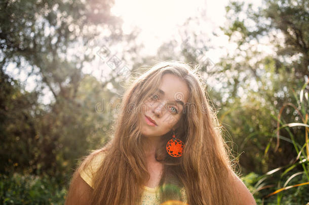 波西米亚风格的女孩，长发金发摆在高高的树前，公园复古颜色背光拍摄