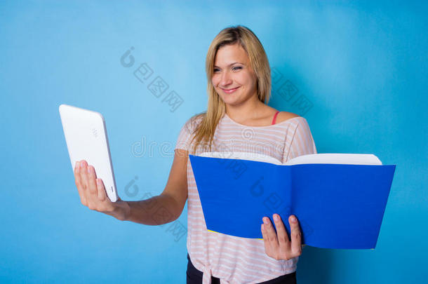 金发女人在书和平板电脑之间选择