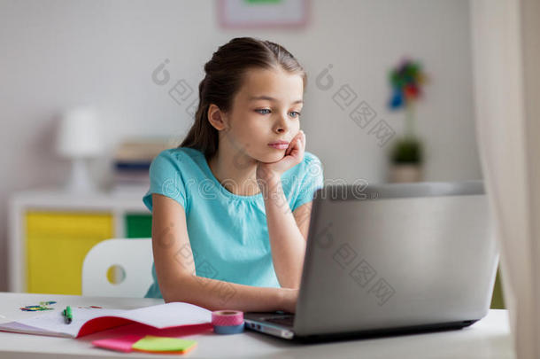 无聊的女孩在家拿笔记本电脑和笔记本