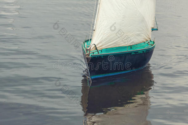 船有白色的帆，漂浮在水中，靠近。