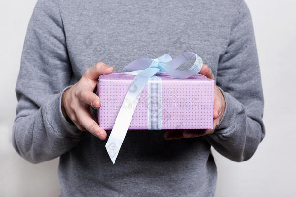 由男人拿着白色丝带的礼物特写。 礼品盒。 生日，新年，情人节`3月8日，圣诞节概念。 a