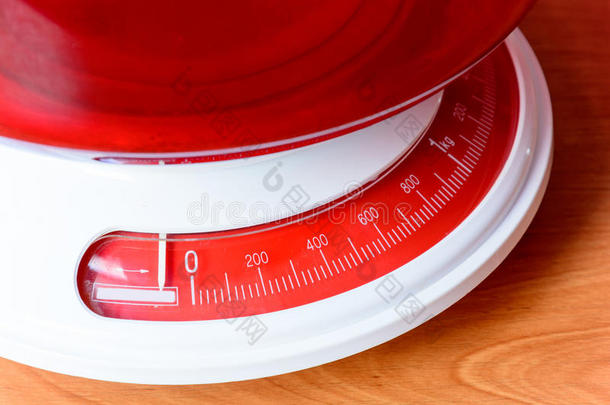 木制桌子上的模拟红色厨房秤