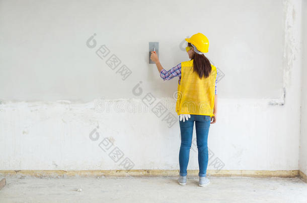 女<strong>职工</strong>，家中劳动抹灰白色混凝土墙，房屋建筑工地