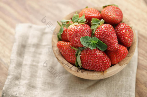 桌子上餐巾上碗里的新鲜草莓