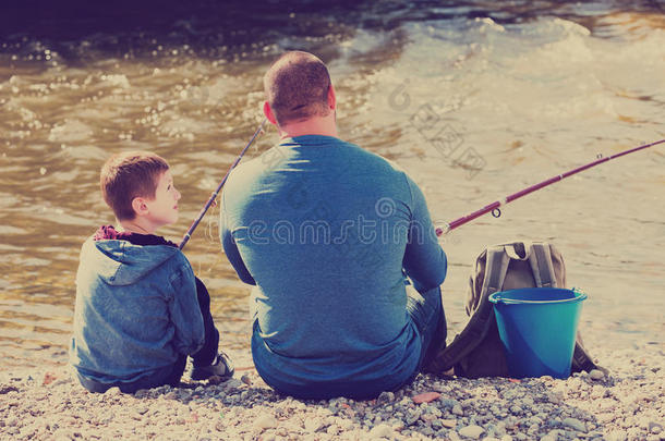 父子在野河里钓鱼