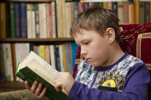 孩子在家看书。 图书馆里的男孩