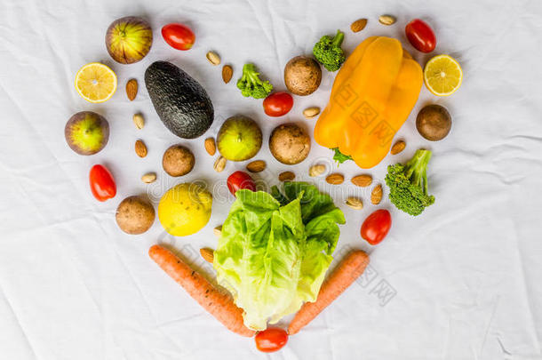 新鲜的水果和蔬菜，谷物和坚果在白色背景上的心脏形状。