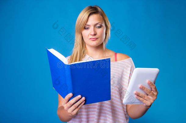金发女人在书和平板电脑之间选择