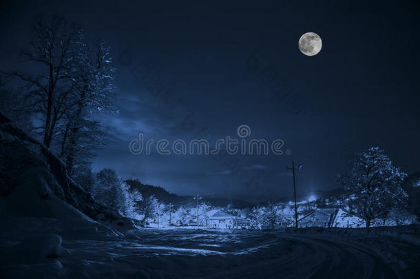 森林在一片充满雪的草地上，在高山上，晚上在满月的光线下，有雪顶。 阿塞拜疆。 莱里克