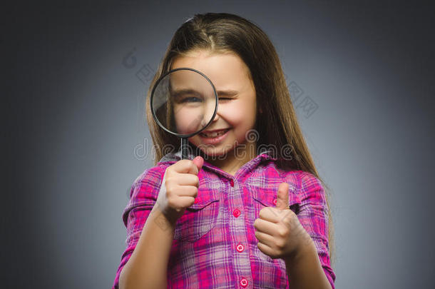 男孩透过放大镜看到，孩子的眼睛看着放大镜镜头超过灰色