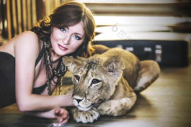 美丽时尚的年轻女人和一个小狮子幼崽