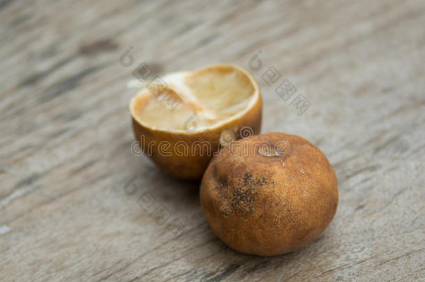 憔悴成熟的柠檬滴在棕色的木地板上。 木头锯克莱