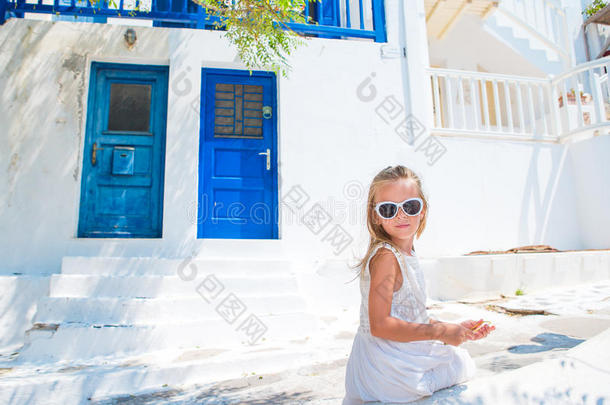 可爱的小女孩在街道上的典型希腊传统村庄在Mykonos岛，在希腊