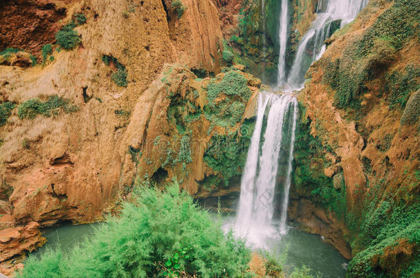 摩洛哥乌苏德瀑布的美丽照片，有柔软的流水和大型彩色岩石。 绿色的野生丛林