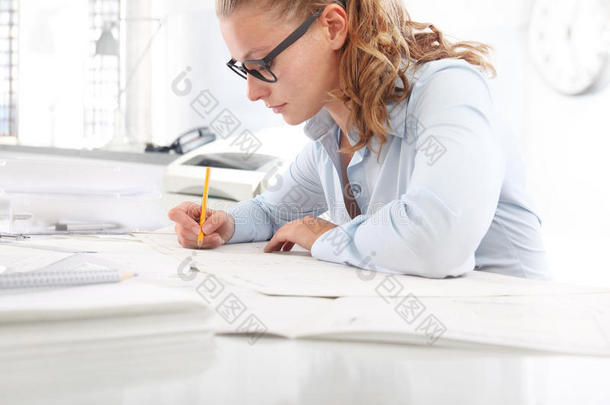 建筑师用铅笔在办公室的办公桌上绘制蓝图