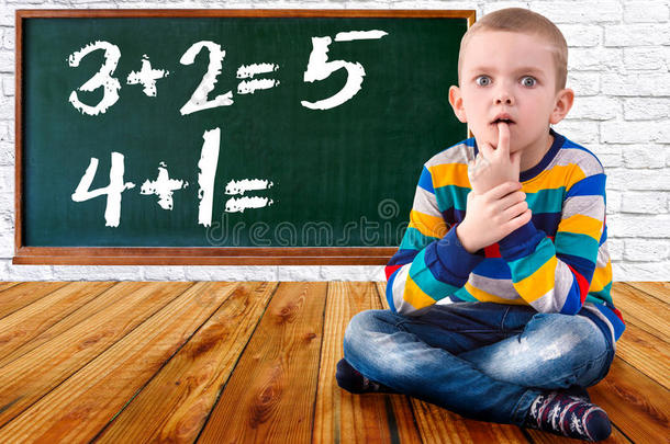 小男孩解决<strong>数学</strong>例子。学生在黑板附近思考和感觉。<strong>数学</strong>任务。