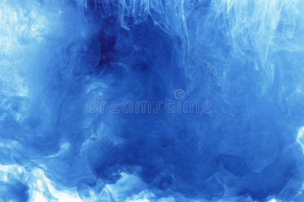 抽象背景颜色墨水滴在水中。 白色的蓝色颜料云。