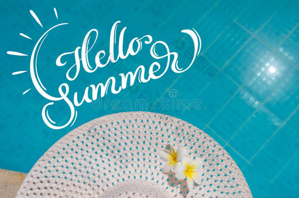 巨大的白色女帽靠近游泳池和短信你好夏天。 书法刻字