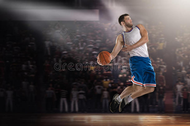 篮球运动员在灯光下带球在体育场上跳跃